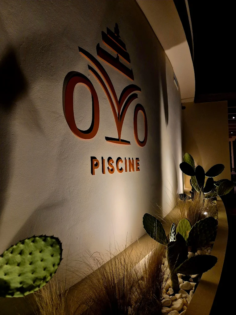 OvO Piscine entrance wall with illuminated logo at night